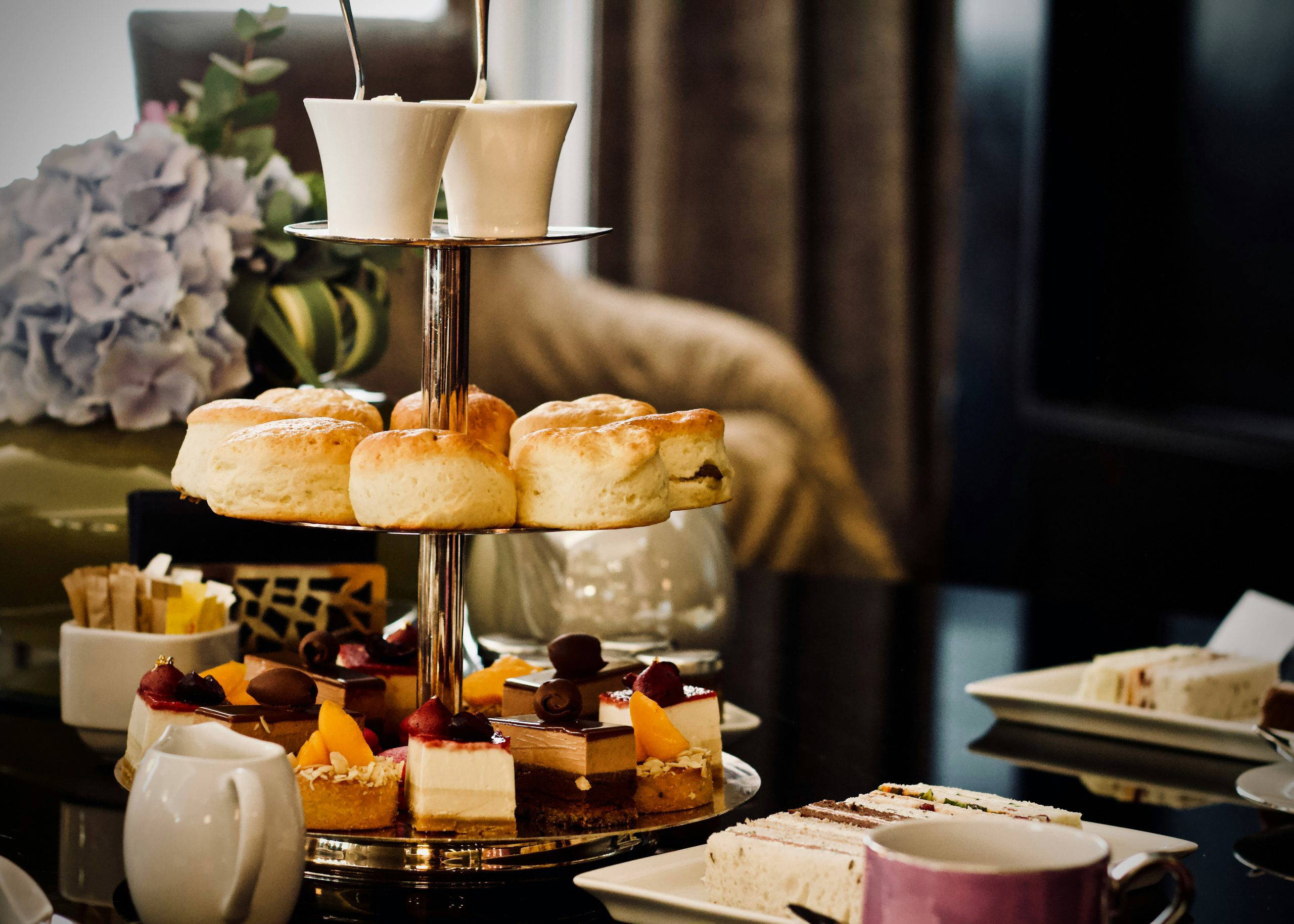 An elegant tiered afternoon tea stand filled with scones, cakes and pastries, representing the thoughtful catering After can arrange for a wake or memorial service.