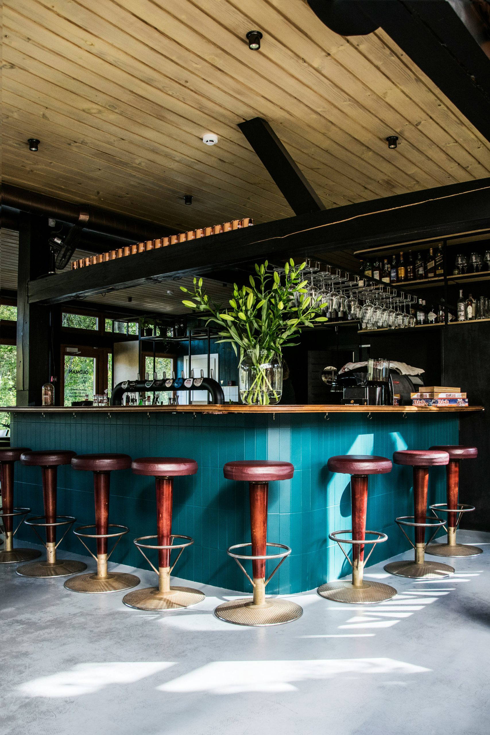 A stylish bar interior with stools and well-stocked shelves, representing one of the many venue styles After can source for a wake, memorial or living funeral in Devon.